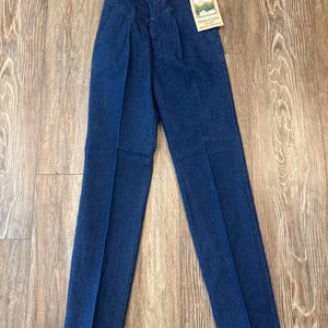 Puede incluir: Vaqueros Wrangler Silver Edition de mezclilla azul con cintura alta y pliegues. Los vaqueros tienen cierre de bot&oacute;n y una etiqueta adjunta. Los vaqueros est&aacute;n hechos de un material de mezclilla duradero.