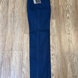 Puede incluir: Pantalones vaqueros azul oscuro con dise&ntilde;o de pernera recta. Los pantalones tienen un estilo cl&aacute;sico de cinco bolsillos y cremallera. Una etiqueta con la marca "Wrangler SilverCake" est&aacute; adjunta.