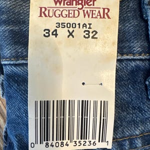 May include: A white tag with black text that reads "Wrangler Rugged Wear 35001A1 34 x 32" and a barcode with the number "0 84084 35236 1".