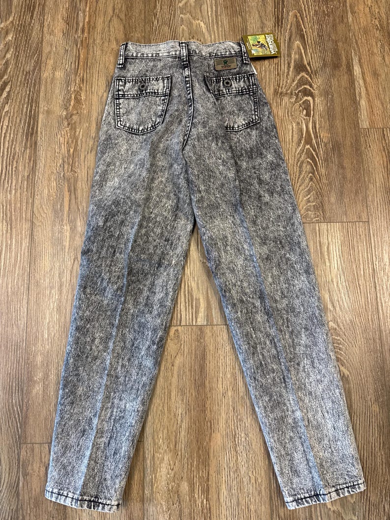 K&ouml;nnte beinhalten: Jeans aus Acid-Wash-Denim mit hohem Bund und zwei Ges&auml;&szlig;taschen. Die Jeans haben ein klassisches F&uuml;nf-Taschen-Design und ein gerades Bein. Der Denim ist eine Mischung aus Grau und Schwarz mit einem verblichenen, strukturierten Aussehen. Ein Etikett ist an der Ges&auml;&szlig;tasche befestigt.