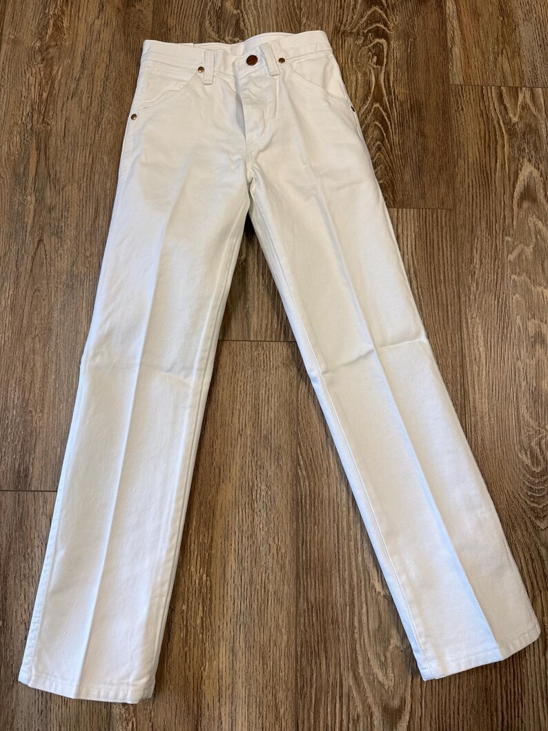 K&ouml;nnte beinhalten: Wei&szlig;e Jeanshose mit klassischem F&uuml;nf-Taschen-Design. Die Hose hat einen Knopf- und Rei&szlig;verschluss, G&uuml;rtelschlaufen und eine gerade Beinpassform. Die Hose ist aus robustem Denim-Material gefertigt.
