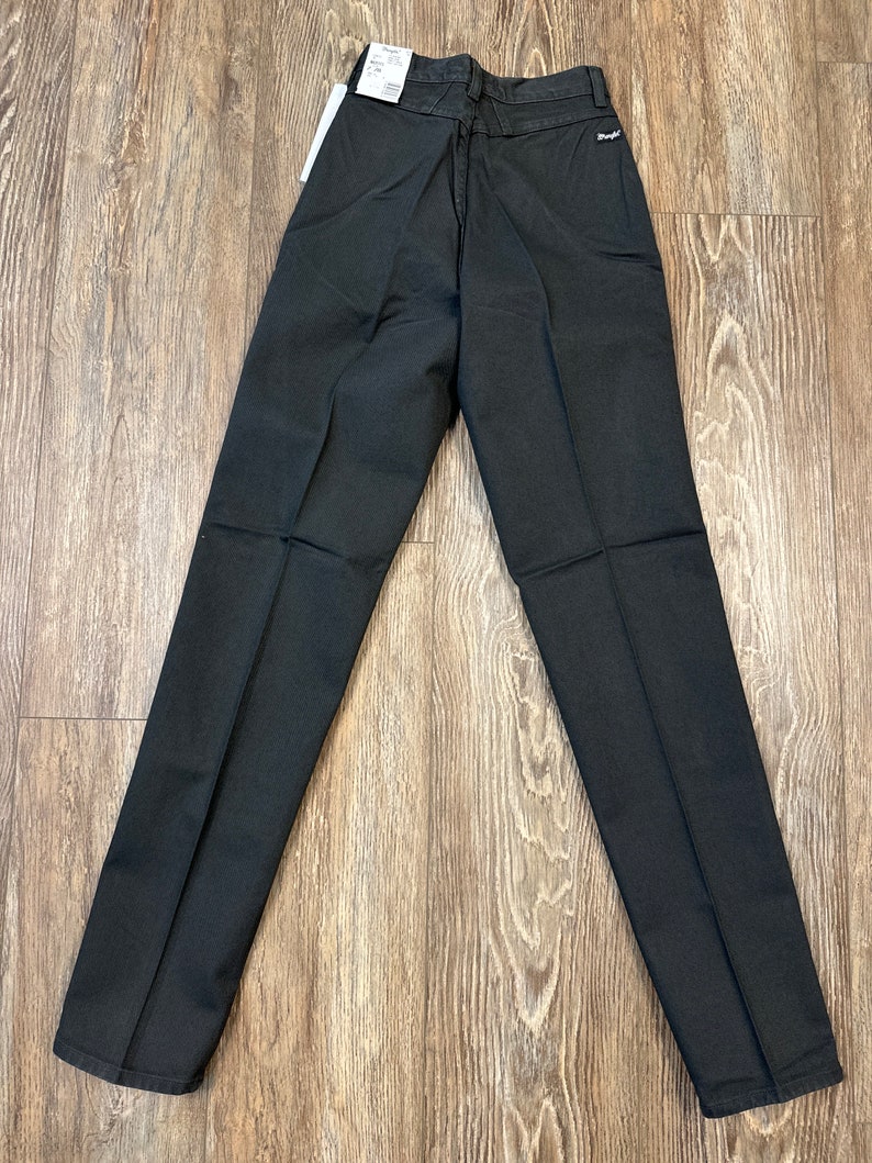 Op de afbeelding: Zwarte rechte broek met een achterzak en een klein label op de achterkant van de tailleband met de tekst "Wrangler".