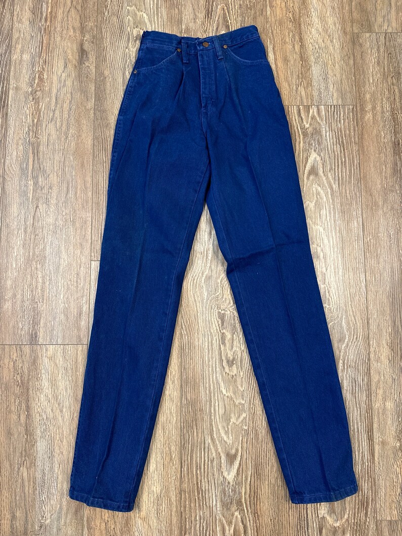 May include: A pair of dark blue denim jeans with a high waist and a straight leg.
