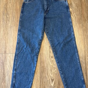 May include: A pair of blue denim jeans with a straight leg fit. The jeans have a button fly and belt loops.