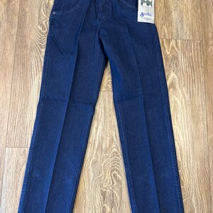 May include: Dark blue denim jeans with a classic fit. Features include a button and zipper closure, front pockets, and a Wrangler brand tag. The jeans have a straight leg design.