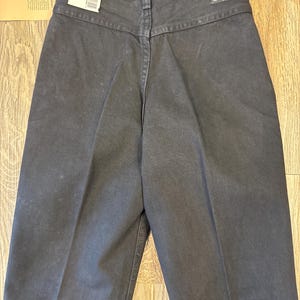 K&ouml;nnte beinhalten: Schwarze Wrangler Jeans mit hoher Taille und geradem Bein. Die Jeans haben ein Etikett am hinteren Bund, auf dem "Wrangler" und "2.78" steht.