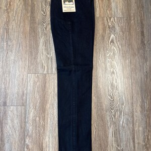 K&ouml;nnte beinhalten: Eine schwarze Jeans mit einem Wrangler Silverlake-Etikett. Die Jeans hat eine gerade Passform.