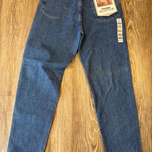 May include: A pair of blue denim jeans with a Wrangler Rugged Wear label. The jeans have a relaxed fit and a straight leg.