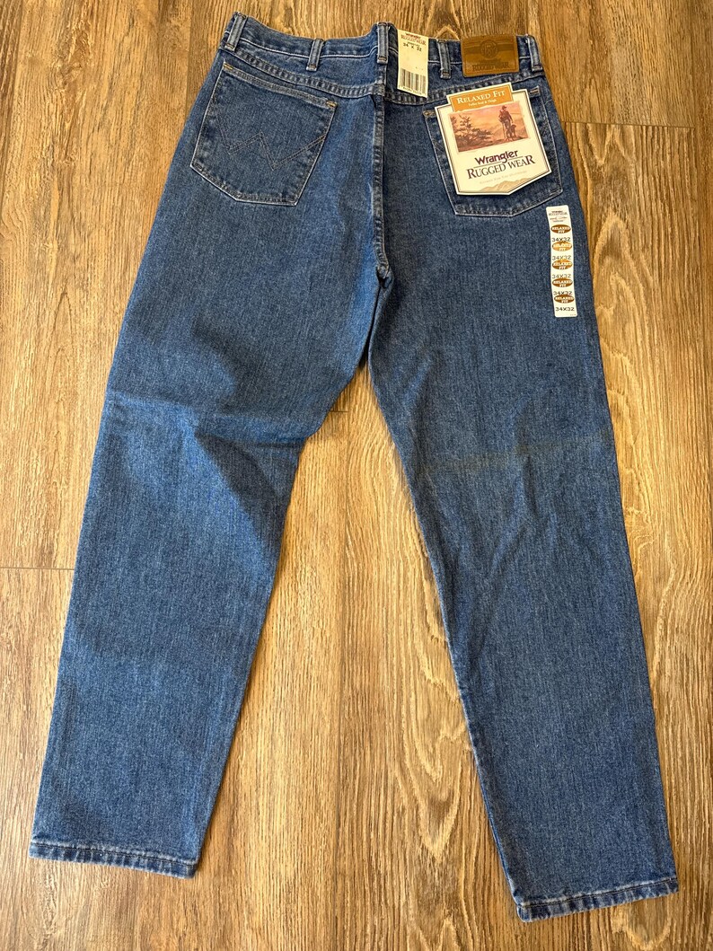 May include: A pair of blue denim jeans with a Wrangler Rugged Wear label. The jeans have a relaxed fit and a straight leg.