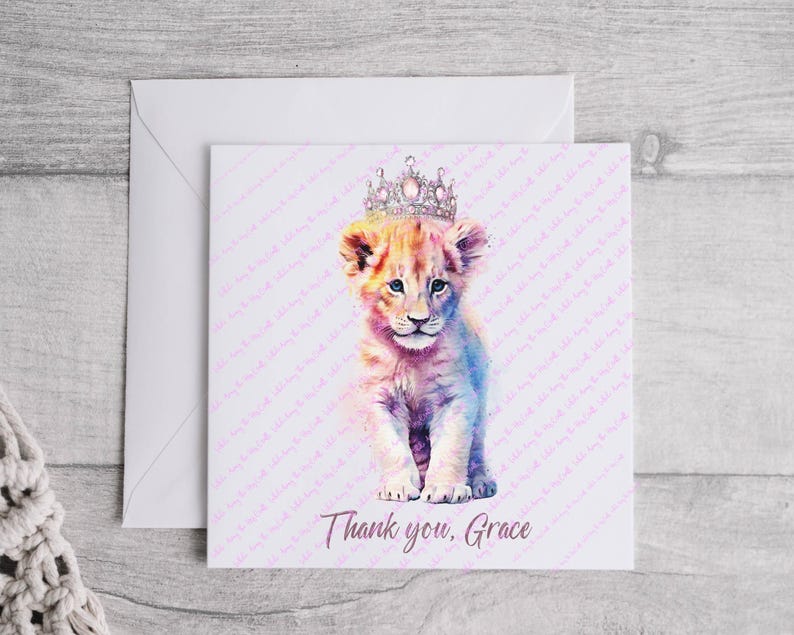 K&ouml;nnte beinhalten: Eine Aquarell-Illustration eines L&ouml;wenjungen mit einer glitzernden Krone. Der Junge ist hellbraun mit rosa und blauen Akzenten. Der Hintergrund ist wei&szlig; mit einem rosa Muster. Der Text "Danke, Grace" befindet sich am unteren Rand der Karte.