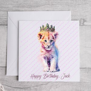 K&ouml;nnte beinhalten: Eine Geburtstagskarte mit einer Aquarell-Illustration eines L&ouml;wenjungen, der eine glitzernde Krone tr&auml;gt. Die Karte hat einen rosa und wei&szlig;en Hintergrund mit dem Text "Happy Birthday, Jack".