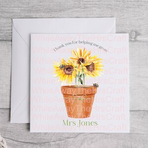 May include: A square greeting card with a watercolour illustration of sunflowers in a terracotta pot. The card has the text "Thank you for helping me grow" and "Mrs Jones". A white envelope is behind the card.