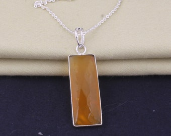 May include: A silver chain necklace with a rectangular pendant featuring a yellow gemstone.