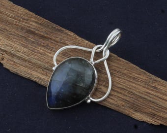 May include: A silver pendant with a teardrop-shaped labradorite gemstone. The pendant has a delicate, openwork design.