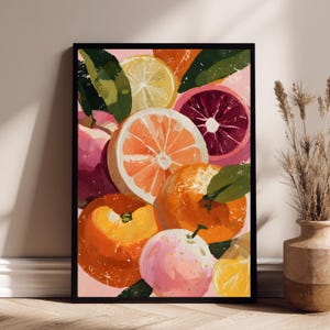 Op de afbeelding: Een ingelijste kunstdruk met een stilleven van citrusvruchten. Het schilderij toont sinaasappels, citroenen en grapefruits in tinten oranje, geel, roze en rood, met groene bladeren. Het kunstwerk is geplaatst tegen een zachtroze achtergrond.