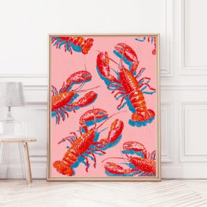 Op de afbeelding: Een ingelijste kunstdruk met een herhalend patroon van rode kreeften en blauwe schaduwen op een roze achtergrond. Het kunstwerk is in pop-art stijl en wordt gepresenteerd in een gouden lijst. De print is een decoratief stuk voor een muur.