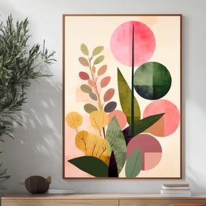 May include: Abstract art print featuring a botanical design. The artwork showcases a variety of shapes, including circles and leaves, in shades of pink, green, yellow, and brown. The print is framed in a wooden frame and is displayed on a light-colored wall.