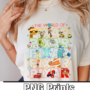 May include: A white t-shirt with a colorful graphic design featuring the word "PIXAR" repeated five times. Each "PIXAR" is surrounded by different characters from popular Pixar movies, including Woody, Buzz Lightyear, Mike Wazowski, Dory, and Lightning McQueen. The text "THE WORLD OF" appears above the graphic design.