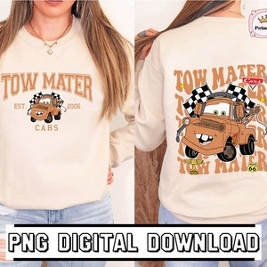 May include: A beige sweatshirt with a graphic print of Tow Mater from the Cars movie. The graphic includes the text "Tow Mater" in a retro font, the text "Cars" in a smaller font, and the text "Est. 2006" in a smaller font. The graphic also includes a checkered flag and the number 66.