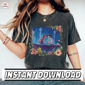 May include: A dark gray t-shirt with a graphic print of Ariel and Prince Eric from The Little Mermaid. The graphic is surrounded by a floral border. The text "Instant Download" is at the bottom of the image.