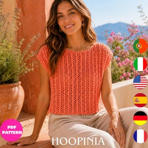 Peut inclure: Un haut en tricot de couleur corail à manches courtes, présentant une texture côtelée verticale avec de petits détails ajourés sur toute la surface. Le vêtement possède une large encolure arrondie et un ourlet droit, en fil léger.