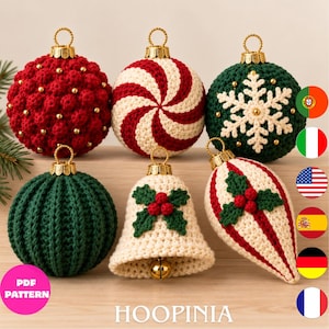Puede incluir: Seis adornos navideños de ganchillo con tapas doradas. El conjunto incluye una bola roja de puntos con cuentas doradas, una bola de espiral roja y blanca, una bola verde con un copo de nieve blanco, una bola verde acanalada, una campana crema con acebo y una forma de lágrima.