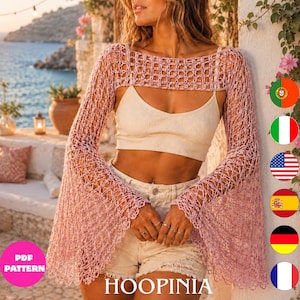 Peut inclure: Un boléro en crochet rose clair avec de longues manches évasées et un motif ajouré. Le vêtement est porté sur un haut court côtelé crème et un short en jean délavé. Le design présente un bord festonné le long des ourlets des manches.