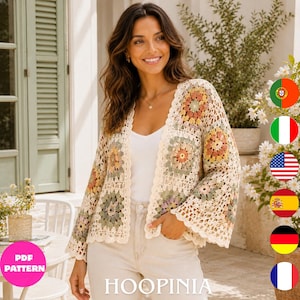 May include: A cream-colored crochet cardigan featuring a multi-colored granny square pattern with floral motifs in shades of sage green, dusty pink, and yellow. The garment has long, wide sleeves, an open front, and a scalloped edge along the hem.