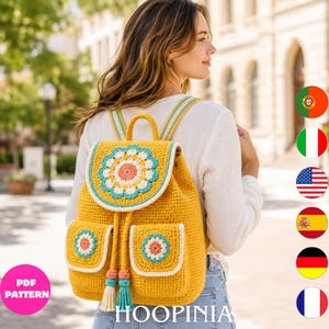 Peut inclure: Un sac à dos en crochet jaune moutarde avec un grand motif floral sur le rabat et deux poches avant, chacune ornée d'une petite fleur assortie. Le sac comprend une fermeture à cordon avec deux pompons et des bretelles rayées.