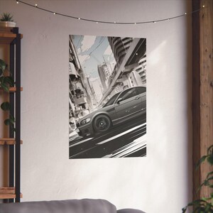 May include: A black car speeding through a city street with tall buildings and a gray sky in the background.