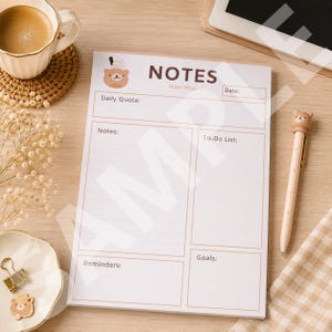 Puede incluir: Un bloc de notas de papel blanco con una ilustración de un oso pardo y el texto NOTES, Clauri Shop, Daily Quote, Notes, To-Do List, Goals y Reminders. El bloc presenta un diseño de cuadrícula con secciones para la planificación diaria.