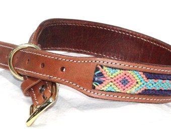 May include: A brown leather dog collar with a white stitched border and a colorful woven design. The collar has a gold metal buckle and D-ring.