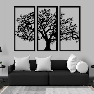 K&ouml;nnte beinhalten: Drei schwarze Wandbilder aus Metall mit der Silhouette eines Baumes mit &Auml;sten. Die Paneele sind horizontal angeordnet und an einer grauen Wand &uuml;ber einem schwarzen Sofa angebracht.