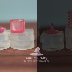 May include: Two sets of clear glass candle holders with pink lids. The candle holders have a textured design. The lids have a small knob on top.