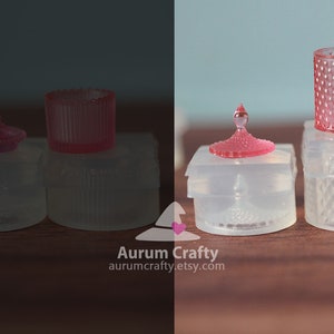 May include: Four clear glass containers with pink lids. The containers are of different shapes and sizes. The lids are all decorated with a diamond pattern.