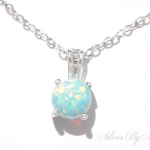 May include: A silver chain necklace with a round opal pendant. The opal is a light blue colour with white and yellow flashes.