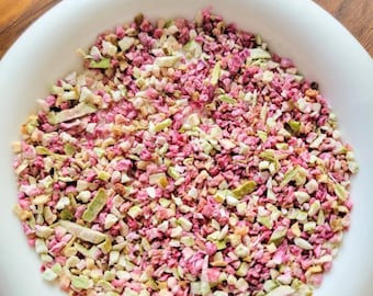 Puede incluir: Un bol blanco lleno de una mezcla de frutas y verduras secas. La mezcla es una combinación de trozos rosados, blancos y verdes.