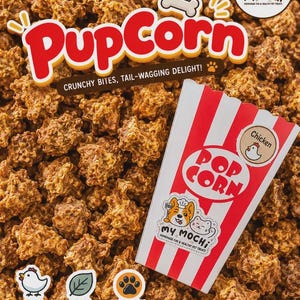 May include: A pile of brown, crunchy pet treats labeled PupCorn with a red and white striped popcorn bag featuring a chicken icon, the text My Mochi, and labels stating Real Chicken, 100% Natural, Made with Love, No Additives, No Preservatives, Grain Free.