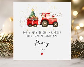 May include: A Christmas card featuring a red tractor pulling a trailer with a Christmas tree and gifts. Santa Claus and a reindeer are in the tractor. The card reads "For a very special grandson with love at Christmas" and is signed "Harry 2026".
