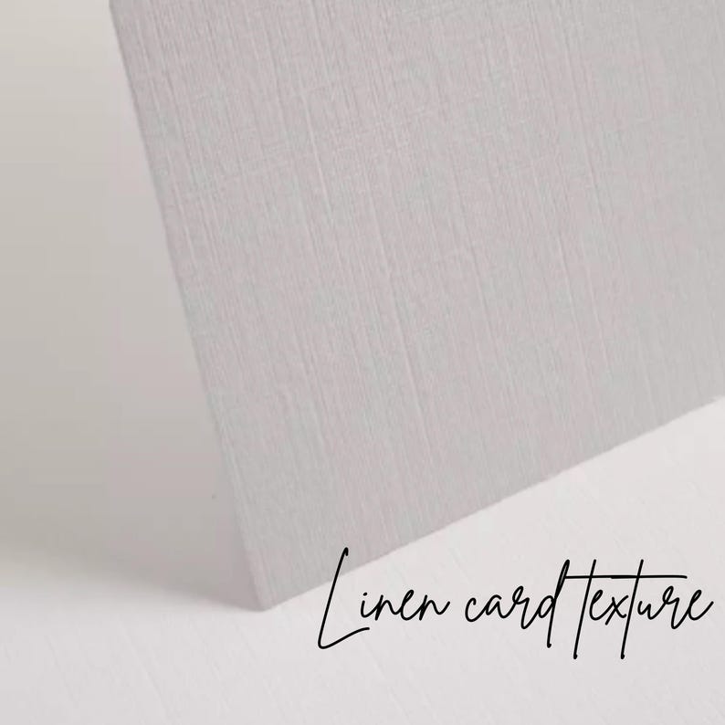 K&ouml;nnte beinhalten: Nahaufnahme einer hellgrauen Karte mit Leinenstruktur. Die Karte ist abgewinkelt und zeigt ihre Kante und die Textur des Papiers. Die Worte "Linen card texture" sind in Schreibschrift geschrieben.