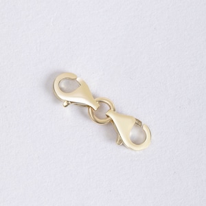 May include: Gold-toned metal clasp with two lobster claw clasps and a connecting ring.