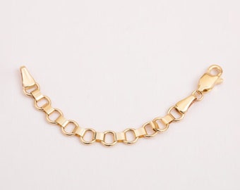 May include: Gold chain extension with a lobster clasp. The chain is made of small, round links. The image shows a close-up of the chain, with a birthstone or letter charm attached to the end. The charm is a blue stone and a letter D.
