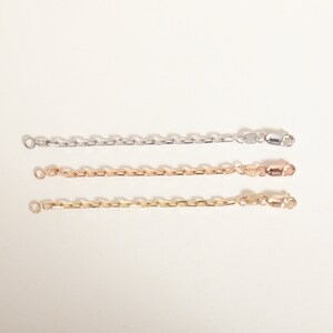 May include: Three chain necklaces in different colors: silver, rose gold, and gold. Each necklace has a lobster clasp closure.