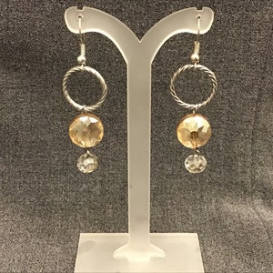 May include: Silver hoop earrings with a faceted gold bead and a clear crystal bead dangling below.