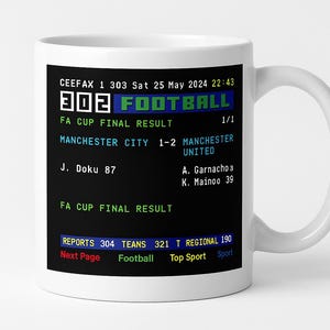 May include: White ceramic mug with a retro football score display. The mug displays the FA Cup Final result, including the word "FOOTBALL" and the score of a match between Manchester City and Manchester United.