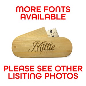 Op de afbeelding: Een houten USB-stick met een gepersonaliseerde inscriptie die "Millie" luidt. De stick is open en de USB-connector is zichtbaar. De tekst "MEER LETTERTYPES BESCHIKBAAR" en "BEKIJK ANDERE LISTINGSFOTO'S" wordt in rood weergegeven.