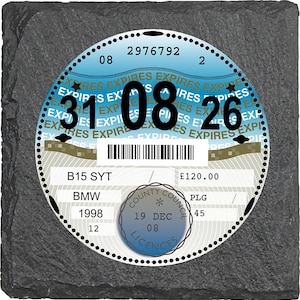 Può includere: Un contrassegno fiscale per veicoli con data di scadenza 26 agosto, su un quadrato grigio scuro strutturato. Il disco presenta un design blu e bianco con la parola "EXPIRES" ripetuta. Il disco include anche il testo "BMW 1998".