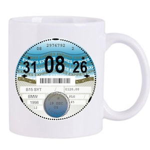 Può includere: Tazza in ceramica bianca con un design circolare con la scritta "EXPIRES" e la data "31 08 26". Il design include un codice a barre e il testo "B15 SYT BMW 1998 12". La tazza ha un manico curvo.