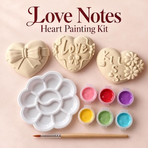 May include: A Love Notes Heart Painting Kit featuring three beige heart-shaped plaques with embossed designs of a bow, the word Love, and the word Kiss with flowers. Includes a white flower-shaped paint palette, six small paint pots, and a brush.