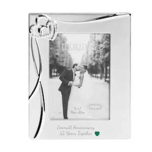 Puede incluir: Marco de fotos plateado con un diseño de corazón y una piedra de esmeralda verde. El marco es para una foto de 13x18 cm y tiene el texto "Celebrations" y "Aniversario de Esmeralda 55 años juntos".